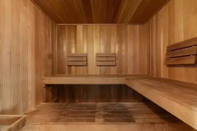 a sauna with wooden walls and two chairs in it at Oceanfront condo with pool hot tub sauna gym bikes tennis - lovely balcony in Santa Rosa Beach