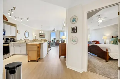 a bedroom with a bed and a kitchen and a living room at Oceanfront condo with pool hot tub sauna gym bikes tennis - lovely balcony in Santa Rosa Beach