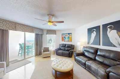 a living room with a leather couch and a table at Coastal condo with beach pool hot tub sauna tennis bikes W&D & central AC in Santa Rosa Beach