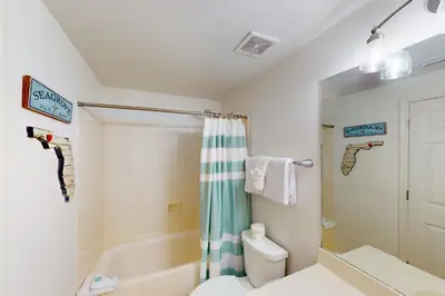 a bathroom with a shower and a toilet and a sink at Coastal condo with beach pool hot tub sauna tennis bikes W&D & central AC in Santa Rosa Beach