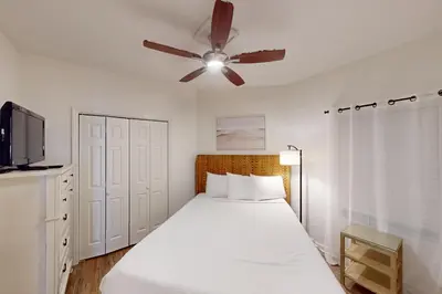 a bedroom with a bed with a ceiling fan at Coastal condo with beach pool hot tub sauna tennis bikes W&D & central AC in Santa Rosa Beach