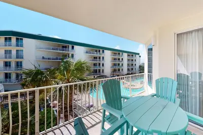 a balcony with a table and chairs and a view of a building at Coastal condo with beach pool hot tub sauna tennis bikes W&D & central AC in Santa Rosa Beach