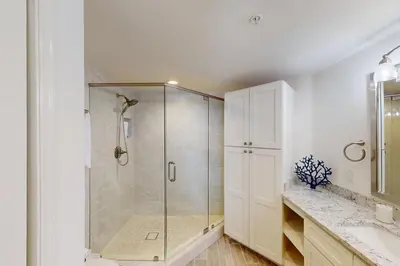 a bathroom with a shower with a glass door at Coastal condo with beach pool hot tub sauna tennis bikes W&D & central AC in Santa Rosa Beach
