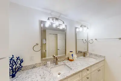 a bathroom with two sinks and a large mirror at Coastal condo with beach pool hot tub sauna tennis bikes W&D & central AC in Santa Rosa Beach