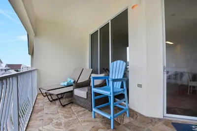 a blue chair sitting on top of a balcony at Dunes of Seagrove condo with pool hot tub sauna gym & tennis pickleball in Santa Rosa Beach