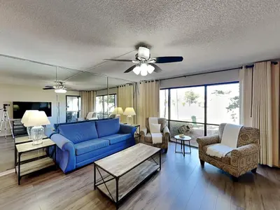 a living room with a blue couch and chairs at Edgewater Villa #2001 in Panama City Beach