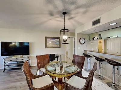 a dining room with a glass table and chairs at Edgewater Villa #2001 in Panama City Beach