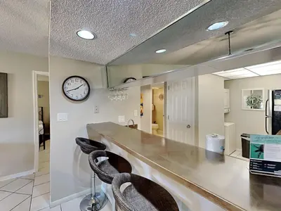 a kitchen with a counter and a clock on the wall at Edgewater Villa #2001 in Panama City Beach