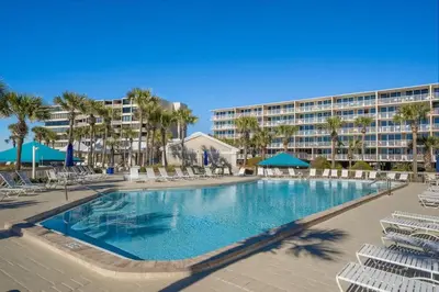 a large swimming pool with chairs and a resort at Dunes of Panama E1702 - Sunrise & Sea Breezes in Panama City Beach