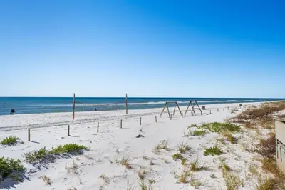 a beach with a swing set in the sand at Dunes of Panama E1702 - Sunrise & Sea Breezes in Panama City Beach