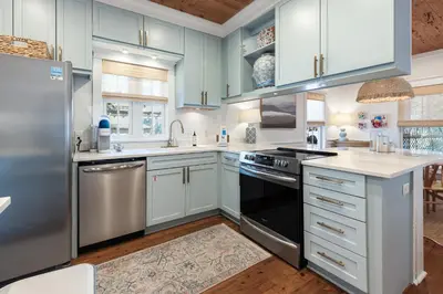 a kitchen with stainless steel appliances and blue cabinets at Fin and Tonic - Magnolia Cottages 3 BR, Heated Community Pool, Bikes in Inlet Beach