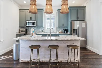 a kitchen with a large island with three bar stools at Seacrest Beach - 3 BR, Bikes, Pool & Beach in Rosemary Beach