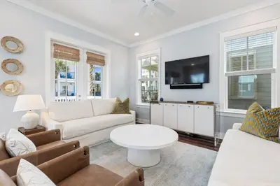 a living room with white furniture and a flat screen tv at Seacrest Beach - 3 BR, Bikes, Pool & Beach in Rosemary Beach