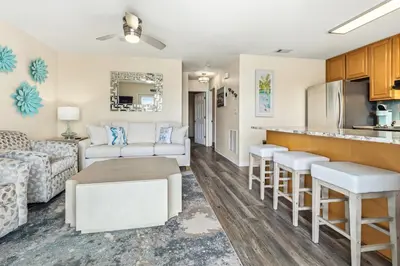 a living room with a couch and a kitchen at New Kululu EAST - 3 BR Short walk to the beach, heated pool, Sleeps 12 in Santa Rosa Beach