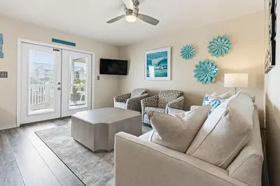 a living room with a couch and a table at New Kululu EAST - 3 BR Short walk to the beach, heated pool, Sleeps 12 in Santa Rosa Beach