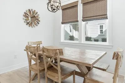 a dining room with a wooden table and chairs at Prominence- 3 BR, steps to the resort style pool, Big Chill & Bikes in Santa Rosa Beach