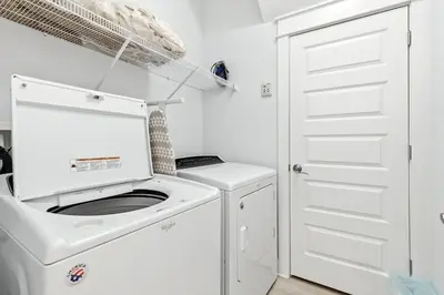 a white laundry room with a washer and dryer at Prominence- 3 BR, steps to the resort style pool, Big Chill & Bikes in Santa Rosa Beach