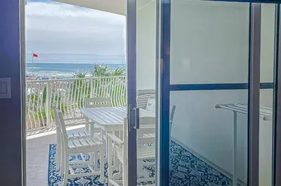 a balcony with a table and chairs and the ocean at Beautifully decorated oceanfront condo with resort pool & huge walk-in showers in Santa Rosa Beach