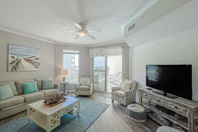 a living room with a large flat screen tv at Beautifully decorated oceanfront condo with resort pool & huge walk-in showers in Santa Rosa Beach