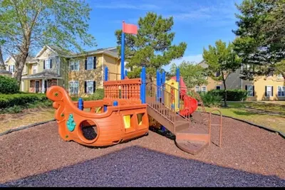 a childs playground with a play equipment in front of a house at Bexley Blue in Panama City Beach
