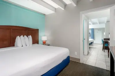 a bedroom with a large bed and a living room at Bikini Beach Resort in Panama City Beach