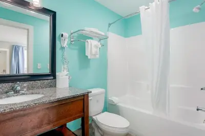 a bathroom with a toilet and a sink and a mirror at Bikini Beach Resort in Panama City Beach