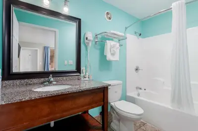 a bathroom with a sink and a toilet and a mirror at Bikini Beach Resort in Panama City Beach