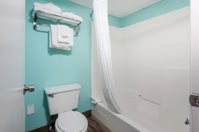 a bathroom with a white toilet and a shower at Bikini Beach Resort in Panama City Beach