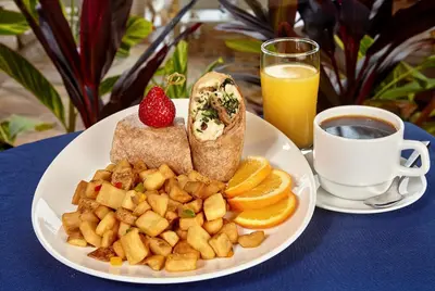 a plate of breakfast food with toast and fruit and a cup of coffee at Holiday Inn Resort Panama City Beach by IHG in Panama City Beach