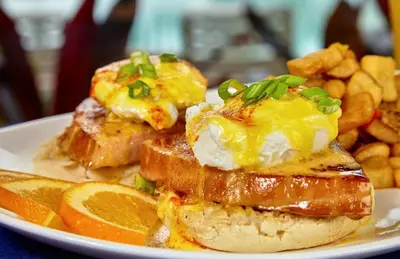 a plate of food with eggs and bread and orange slices at Holiday Inn Resort Panama City Beach by IHG in Panama City Beach