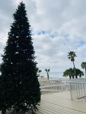 a christmas tree on a boardwalk next to the beach at Holiday Inn Resort Panama City Beach by IHG in Panama City Beach