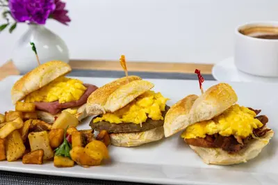 a plate with three breakfast sandwiches and potatoes at Holiday Inn Resort Panama City Beach by IHG in Panama City Beach