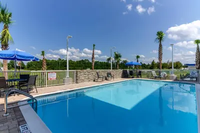 a large blue swimming pool with chairs and umbrellas at Fairfield Inn & Suites by Marriott Panama City Beach in Panama City Beach