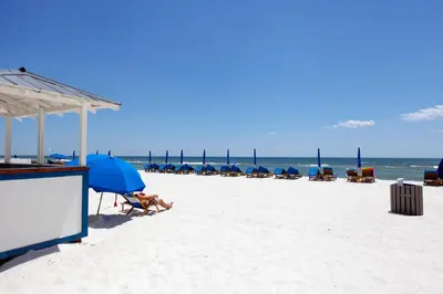 a group of chairs and umbrellas on a beach at Regency Towers by Panhandle Getaways in Panama City Beach