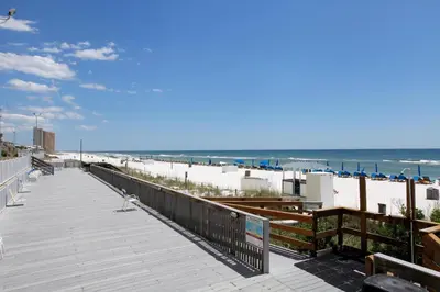 a boardwalk on a beach with the ocean in the background at Regency Towers by Panhandle Getaways in Panama City Beach