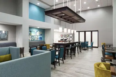 a dining room with chairs and tables in a restaurant at Hampton Inn & Suites Panama City Beach-Pier Park Area in Panama City Beach
