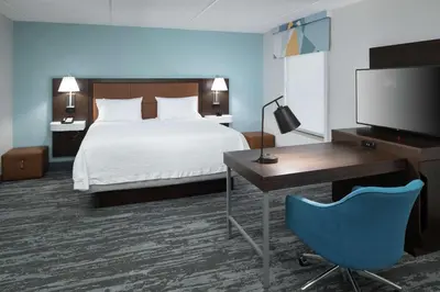 a hotel room with a bed and a desk and a television at Hampton Inn & Suites Panama City Beach-Pier Park Area in Panama City Beach