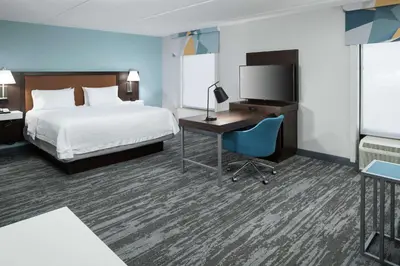 a hotel room with a bed and a desk and a tv at Hampton Inn & Suites Panama City Beach-Pier Park Area in Panama City Beach