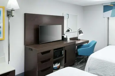 a hotel room with a desk with a television and a bed at Hampton Inn & Suites Panama City Beach-Pier Park Area in Panama City Beach