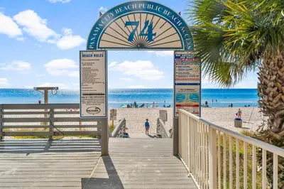 a boardwalk at the beach with a clock on it at Splash Beach Resort by Panhandle Getaways in Panama City Beach