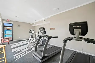 a fitness room with treadmills and ellipticals at Horizon South by Panhandle Getaways in Panama City Beach