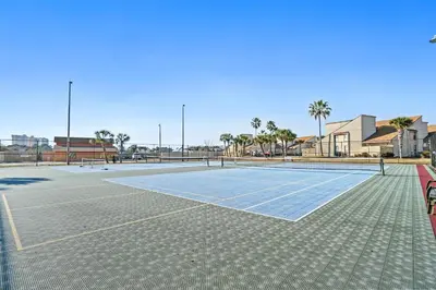 a tennis court with a net on it at Horizon South by Panhandle Getaways in Panama City Beach