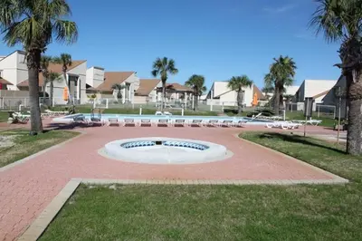 a fountain in a park with palm trees and houses at Horizon South by Panhandle Getaways in Panama City Beach