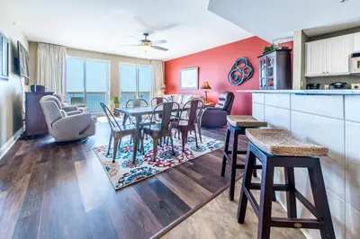 a kitchen and living room with a table and chairs at Calypso 1-609 East in Panama City Beach