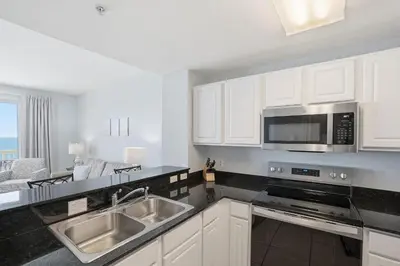 a kitchen with a sink and a microwave at Calypso 2-1907 West in Panama City Beach