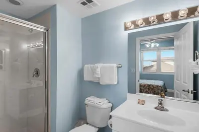a bathroom with a toilet and a sink and a shower at Celadon 309 in Panama City Beach