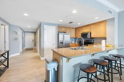 a kitchen with a counter and bar stools at Grandview East 1203 in Panama City Beach
