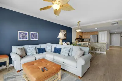 a living room with a white couch and a blue wall at Grandview East 1204 in Panama City Beach