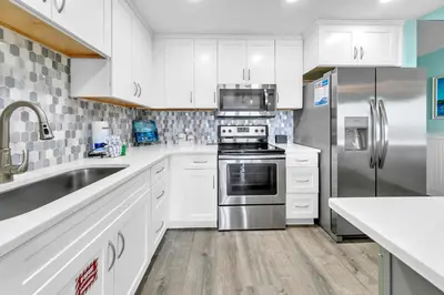 a kitchen with white cabinets and a stainless steel refrigerator at Laketown Wharf 1326 in Panama City Beach
