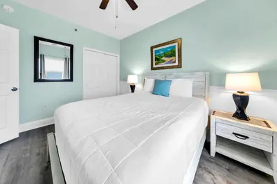 a bedroom with a large white bed and a night stand at Laketown Wharf 1326 in Panama City Beach